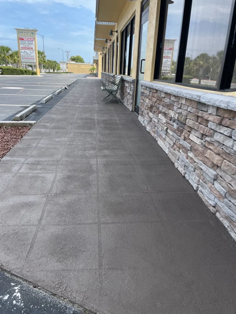 Finished scored concrete commercial walkway beside a storefront